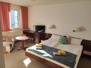 a bedroom with a bed and a desk and a television at Zimmer am Jüdenhof in Heilbad Heiligenstadt