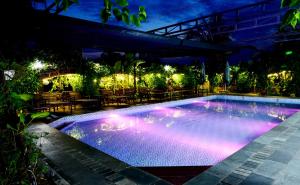 Una piscina de noche con luces encendidas en Tam Coc Amanda Villas, en Ninh Binh