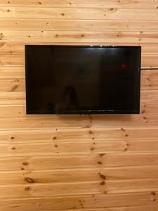 a flat screen tv hanging on a wooden wall at wood house in Mestia