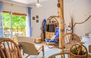 a living room with chairs and a tv at 2 Bedroom Amazing Home In Isla Cristina in Isla Cristina