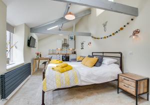 a bedroom with a bed with yellow pillows on it at Cwt Bach in Llanfair Talhaiarn