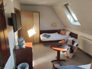 um pequeno quarto com uma cama e uma pequena mesa em Zimmer am Jüdenhof em Heilbad Heiligenstadt