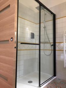 La salle de bains est pourvue d'une douche avec une porte en verre. dans l'établissement Le Nid des Corbières, à Bizanet