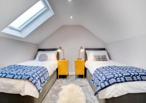 two beds in a attic room with a window at Cwrt y Llyn in Pen-y-groes