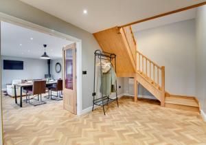 a living room with a staircase and a dining room at Cwrt y Llyn in Pen-y-groes
