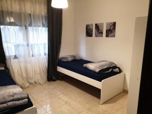 Habitación pequeña con cama y ventana en Dair Ghbar 2-bedrooms unit, en Amán