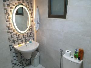 uma casa de banho com um lavatório, um espelho e um WC. em Dair Ghbar 2-bedrooms unit em Amã