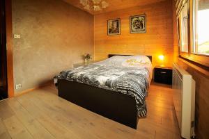 la cache des relles في كسونبورت-لونجمير: غرفة نوم بسرير في غرفة بجدران خشبية