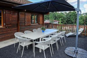 la cache des relles في كسونبورت-لونجمير: طاولة وكراسي تحت مظلة على الفناء