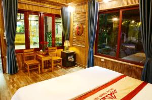 a bedroom with a bed and a table and chairs at Tam Coc Amanda Villas in Ninh Binh