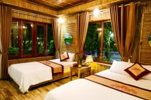 a bedroom with two beds and a window at Tam Coc Amanda Villas in Ninh Binh
