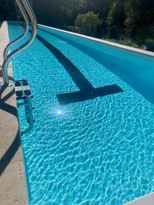 a blue swimming pool with a pooliterator at Maison aux pieds des Pyrénées - Piscine d'exception de 25m in Espoey