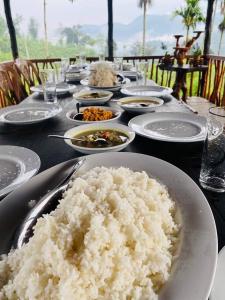a table with white plates of rice on it at Misty Mountain- Sinharaja in Deniyaya