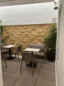 a room with tables and chairs and a stone wall at Enmathi Alicante Benalua in Alicante