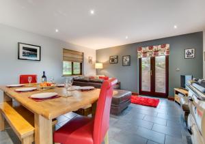 een keuken en een woonkamer met een houten tafel en rode stoelen bij Nant y Llyn in Bala