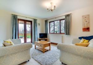 a living room with two couches and a tv at Nant y Llyn in Bala