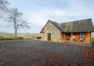 een stenen huis met een grindoprit bij Nant y Llyn in Bala