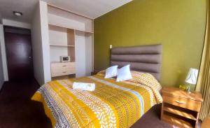 1 dormitorio con 1 cama con 2 toallas en Hotel San Felipe Suites, en Arequipa