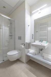 a white bathroom with a sink and a shower at Dom Zdrojowy in Gdańsk