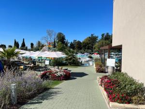 un patio con mesas, sombrillas y flores en Sisan Family Resort, en Bardolino