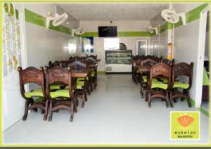 a dining room with chairs and tables and a fishtank at Hotel Mansión del Cesar in Aguachica