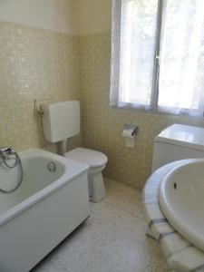 een badkamer met toilet, bad en wastafel bij Chez Mi, centre ville, parking gratuit, arrivée autonome in Saint-Chinian +13 foto's