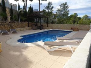 a swimming pool with two chairs and a picnic table at Villa Santorini Costa Blanca in La Nucía