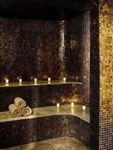 - une salle de bains avec des bougies et des serviettes sur une étagère dans l'établissement Les Villas d Onalou Kergastel, à Penvénan