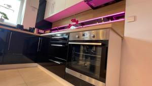 un horno negro en una cocina con iluminación púrpura en #3 TGHA Luxury One Bedroom Apartment in Athlone, en Athlone