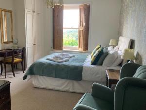 a bedroom with a bed with a table and a window at Malvern View in Cheltenham