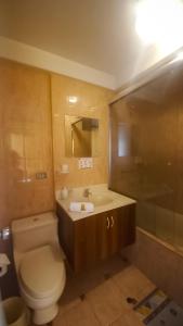 y baño con aseo y lavamanos. en Hotel San Felipe Suites, en Arequipa