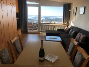 een fles wijn op een tafel in de woonkamer bij Panorama Bayerwald in Neureichenau