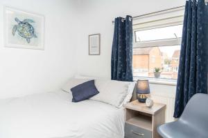 Schlafzimmer mit einem Bett und einem Fenster in der Unterkunft East Street, Town Centre, 2 Bedrooms in Tewkesbury