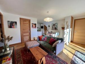 - un salon avec un canapé vert et une table dans l'établissement appartement Shangrila, à Chamonix-Mont-Blanc