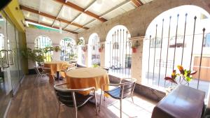 2 mesas y sillas en una habitación con ventanas grandes en Hotel San Felipe Suites, en Arequipa