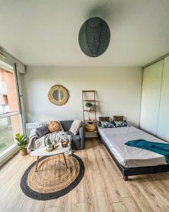 een slaapkamer met een bed, een bank en een tafel bij RANGUEIL - Studio confortable proche hôpital et université in Toulouse