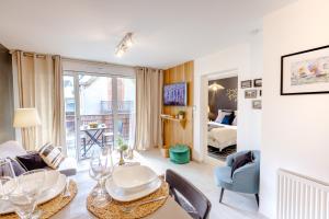 a dining room with a table and chairs and a living room at La Clé Anglaise - WIFI - PARKING - Balcon in Wimereux