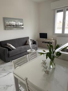 a living room with a white table and a couch at Affitta camere Tra mari e monti in Cecina