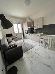 eine Küche und ein Wohnzimmer mit weißem Marmorboden in der Unterkunft Affitta camere Tra mari e monti in Cecina