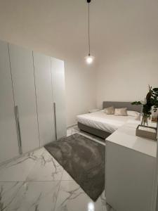 a white bedroom with a bed and a cabinet at Affitta camere Tra mari e monti in Cecina