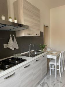 a kitchen with a sink and a stove at Affitta camere Tra mari e monti in Cecina