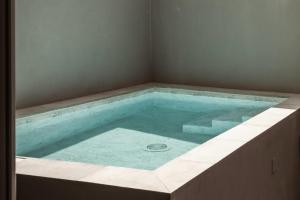 a bath tub with a blue water in it at The Segond Hotel in Xagħra