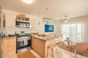 a kitchen and living room with a stove and a couch at 1BR Villa at Green One F2 in Muñoz