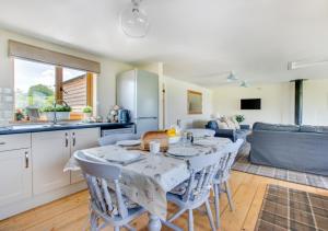 a kitchen and living room with a table and chairs at Caban Cwm Hedd in Bassaleg