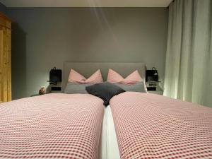 2 łóżka w sypialni z biało-różową pościelą w obiekcie Larix Apartment w mieście Tamsweg