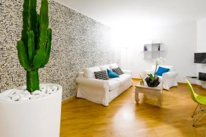 a living room with a white couch and a cactus at Nipare Suite - Dimore Partenopee in Naples