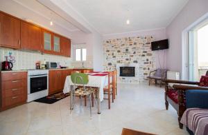 a kitchen and living room with a table and a fireplace at Valtaki Holiday Home in Selinitsa
