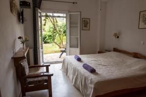 a bedroom with a bed with purple pillows on it at MANESSIS Apartments Kassiopi Bay Corfu in Kassiopi