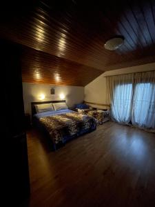 a bedroom with a bed and a wooden ceiling at CASUTA MAGICA in Păuşeşti-Măglaşi