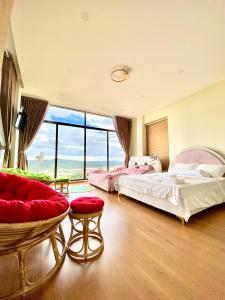 a bedroom with two beds and a large window at Bảo Châu Villa & Coffee Đà Lạt in Da Lat
